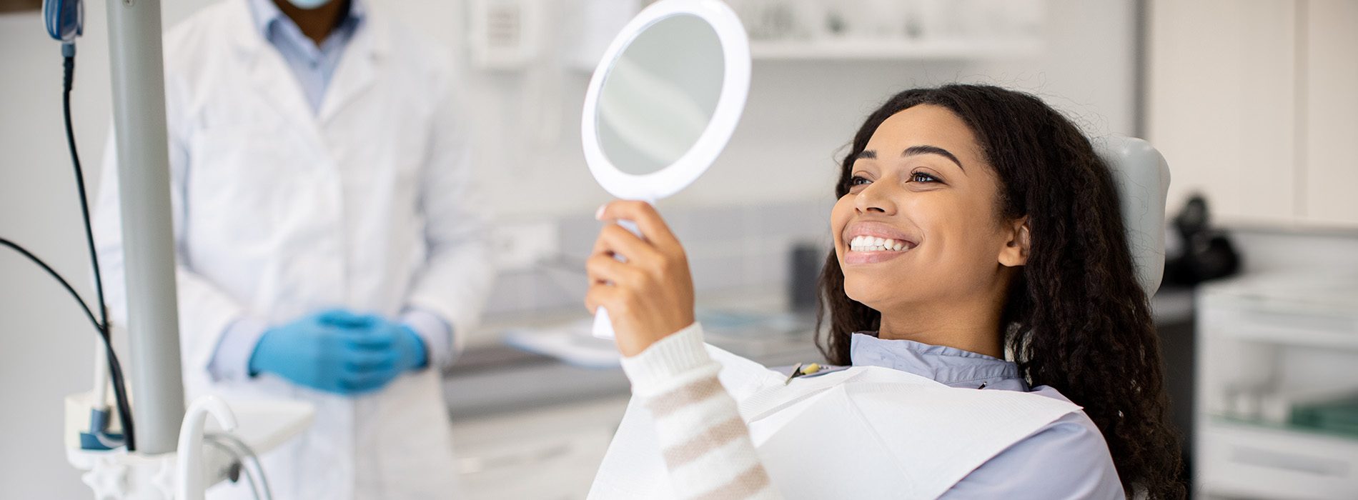 A well-lit reception area with a desk, computer monitor, and potted plant.