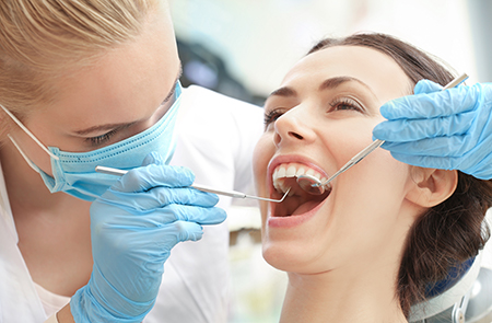 A dental hygienist assisting a patient during a teeth cleaning session in a dental office.